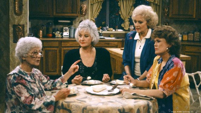 The Golden Girls eating cheesecake together at the table. 